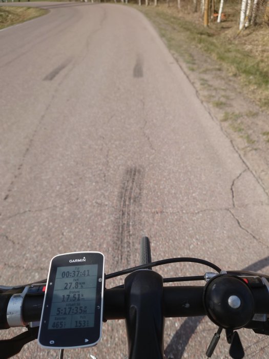 Cyklistens perspektiv med GPS-cyklingsdator på styret som visar hastighet och distans.