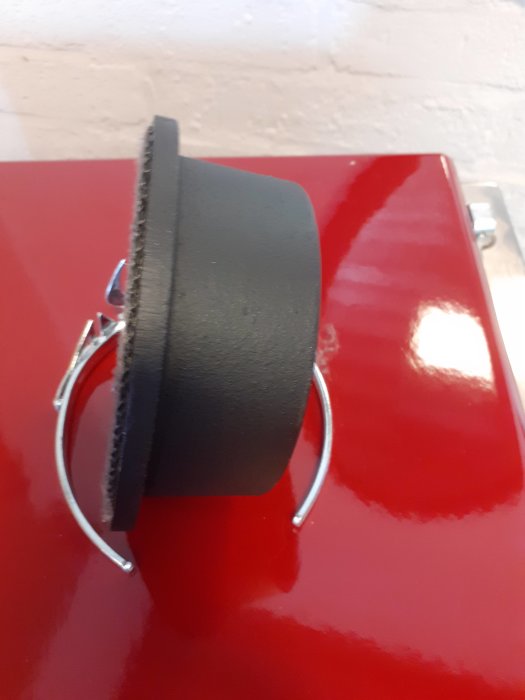 Svart lock med eldfast garn används för att täcka sidorökutgång på röd spispanna.
