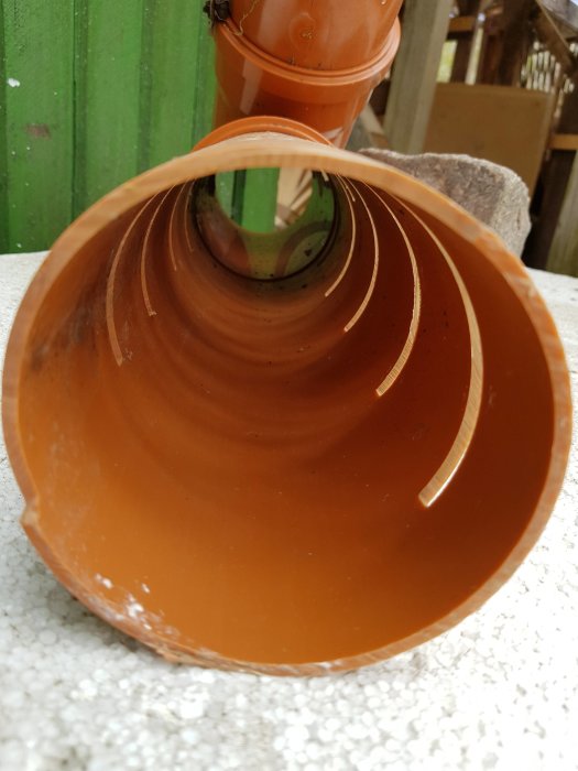 Närbild på en liggande, bruten orange plaströr.