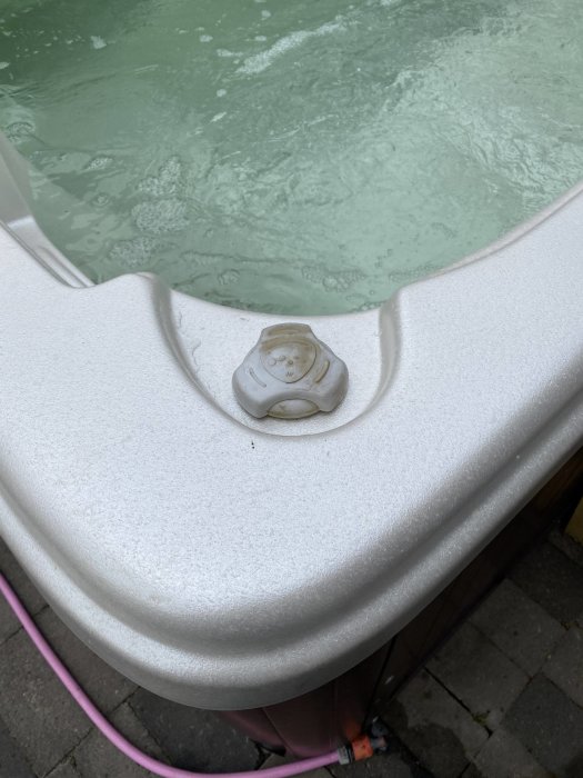 Ett spabad med igångsatta jetstrålar och en del av kontrollpanelen synlig.