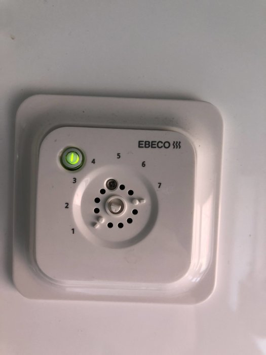 Termostat utan vred märkt Ebeco, inställningsskala från 1 till 6, en grön lysdiod tänd.