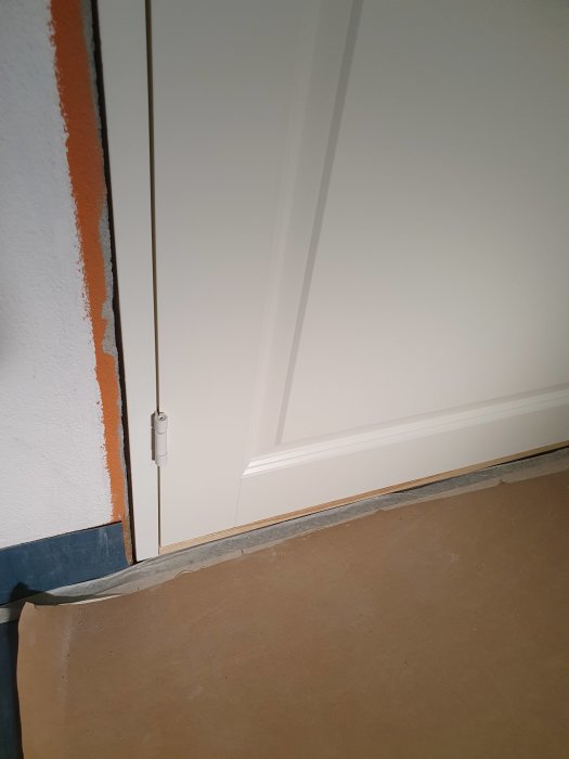 Innerdörr monterad i karm som inte är i lod, vilket syns på glipan nära golvet.