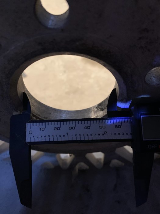 Schackelmätning av däck med digitalt skjutmått som visar mått i millimeter.