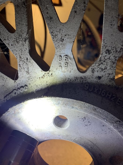 Närbild på däcks märkningar och mönster med siffrorna 369 synliga och belysning från sidan.