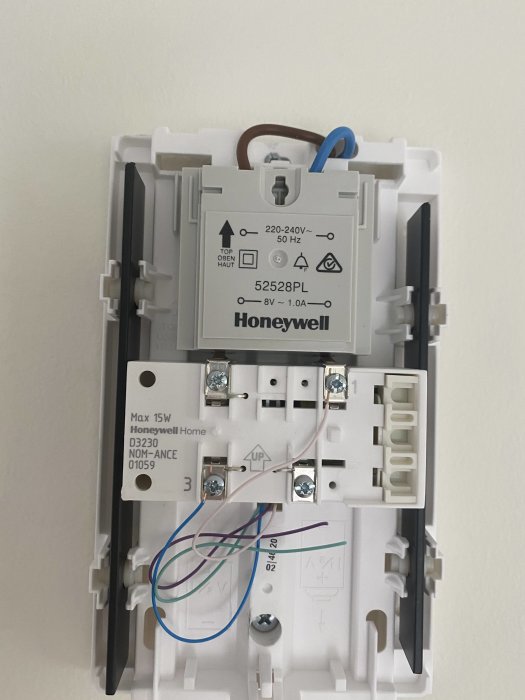 Honeywell-transformator med etikett 8V 1A monterad på vit vägg.