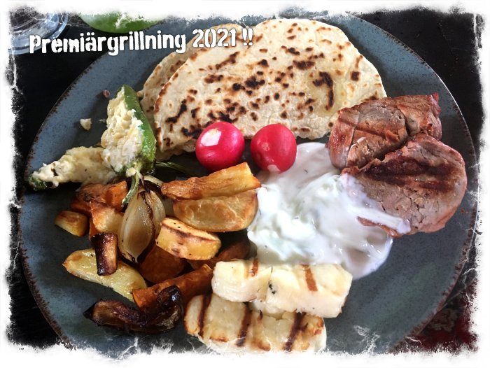Grilltallrik med fläskfilé, tsatsiki, grillost, ugnrostade grönsaker, grillbröd och rädisor.