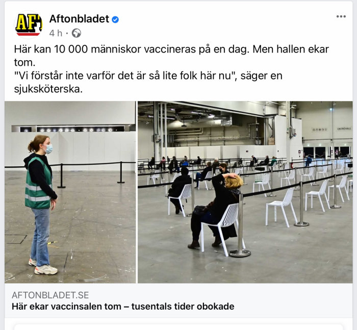 En tom vaccinationshall med glesa besökare och en person stående i förgrunden.