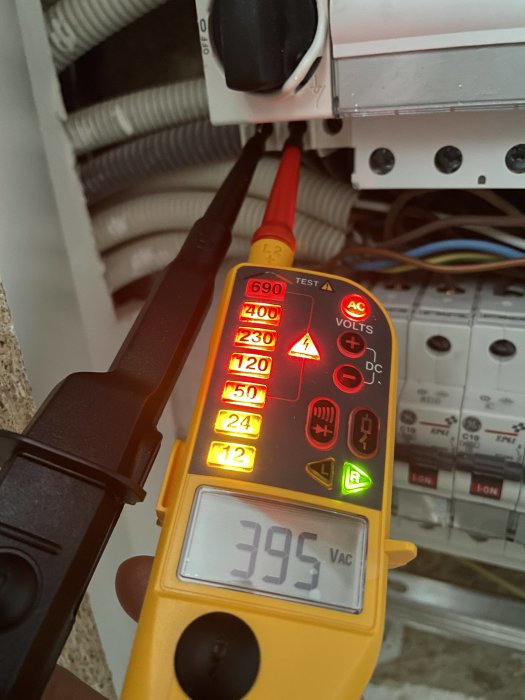 Multimeter visar 395 V AC i en elcentral under mätning av fas till fas.