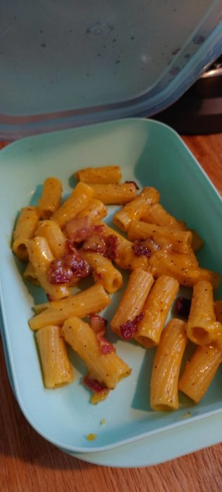 Portion av pasta carbonara med bacon i en matlåda.