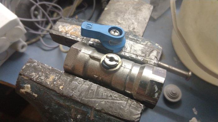 Skadad ventil med utskjuten packning på ett vattenrör i ett garage.