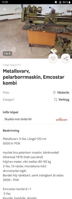 Äldre grön metallsväng och pelarborrmaskin från Emcostar uppställd på gult bord med lösa komponenter och växlar framför på vit bakgrund.