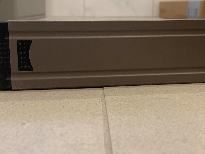 Närbild på kakel med vattenpass som visar ojämnheter i badrumsrenovering.