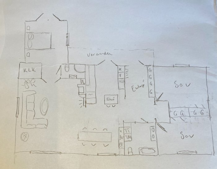 Handritad grov skiss av en husplan med markerad entré, veranda och rumsindelning inklusive kök och badrum.