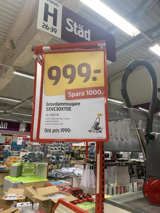 Reaskylt för grovdammsugare SXVC30XTDE i en butik med priset 999 kr, nedsatt från 1999 kr, under en skylt som säger 'Städ'.