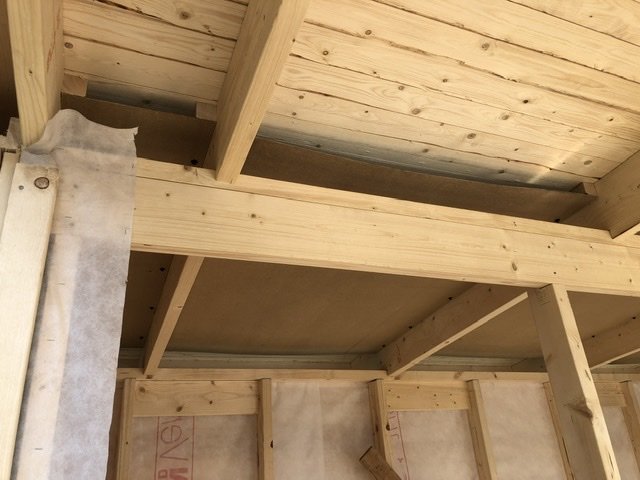 Takbjälkar med oljeboard och dosor för elinstallationer i ett pågående byggprojekt.
