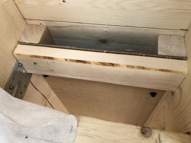 Trähörn med installerade eldosor och rör, förstärkt med farmarskruv och smygvinkel.