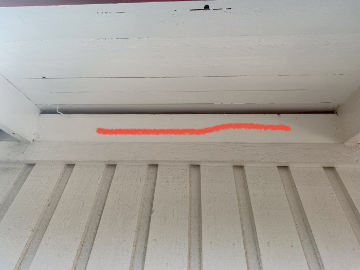 Takfot med en bräda där ett fågelbo har placerats bakom, synligt glapp och oranga markeringen.