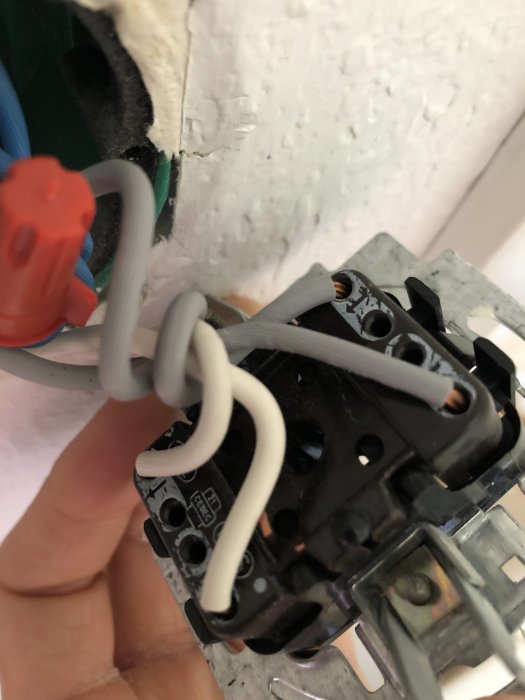 Närbild på en öppen strömbrytare med synliga anslutna kablar under installation.