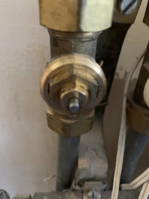 Närbild på en fastsatt metallpigg i ett rörsystem med synliga verktygsspår.