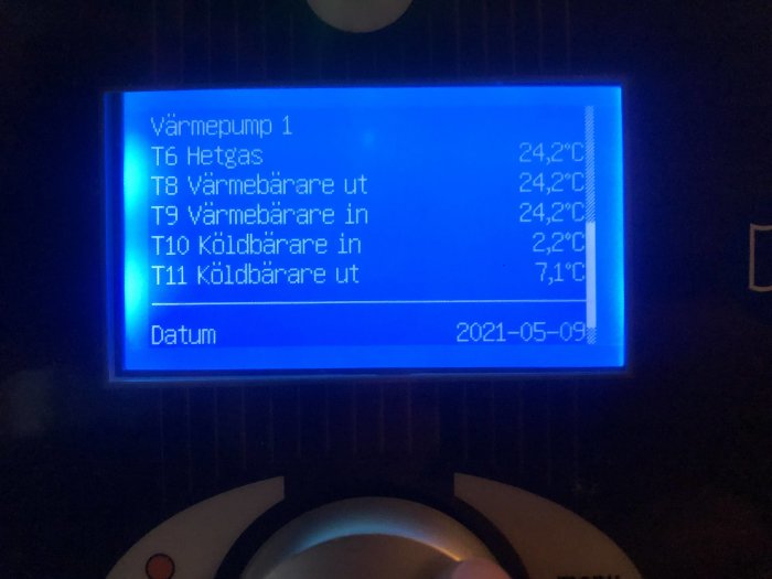 Display på värmepump som visar temperaturvärden och datum från 2021-05-09.