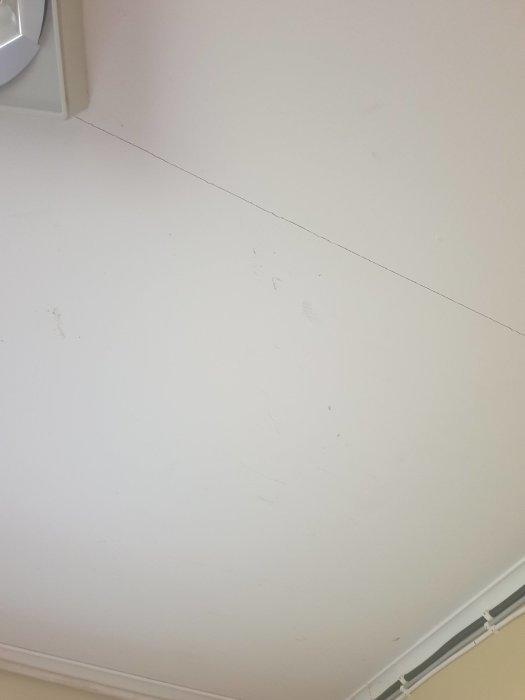 Vitt tak med synliga fläckar före målning, målningsprojekt i hemmet.