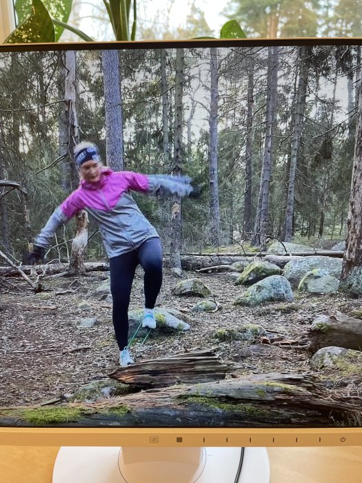 Person balanserar på en stock i skogen, ingen renovering eller byggrelaterad aktivitet syns.
