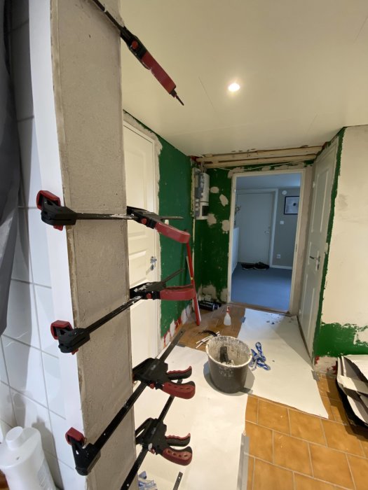 Renoveringsprocess av dörröppning utan dörr, med spackel och verktyg synliga.