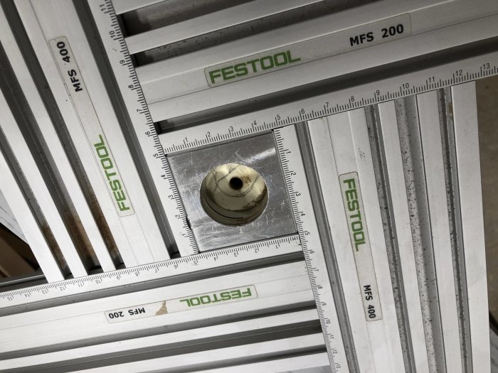 Avbruten mässingsskruv insatt i trämaterial omgiven av Festool MFS 200 och 400 skensystem.