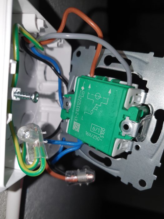 Elektrisk installationsdosa med en nyinstallerad trappomkopplare och anslutna kablar.