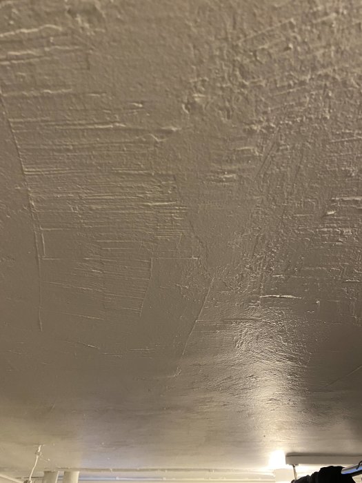 Strukturerat tak i källarbadrum som användare överväger för våtrum, zon 1 och 2.