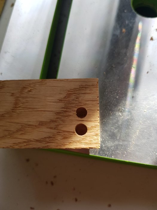 Träbit med två hål, jämförelse av borrkvalitet på ek och metall.