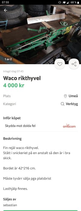 Grön Waco rikthyvel till salu, visas i ett arbetsutrymme med däck staplade i bakgrunden.