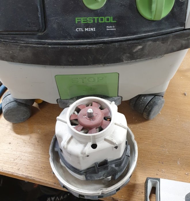 Bytt motor på en Festool CTL MINI dammsugare, ligger på en arbetsbänk med synlig STOP-text.