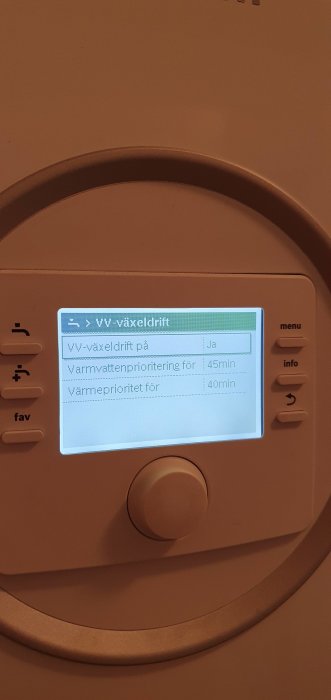 Display av värmepump med inställningsmeny för varmvatten och växeldrift aktiverad.