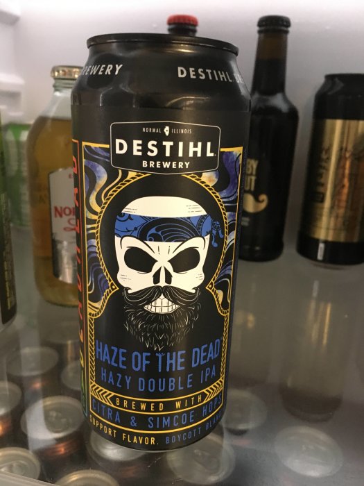 En ölburk från DESTIHL Brewery med namnet "Haze of the Dead Hazy Double IPA", omgiven av andra drycker i kyl.