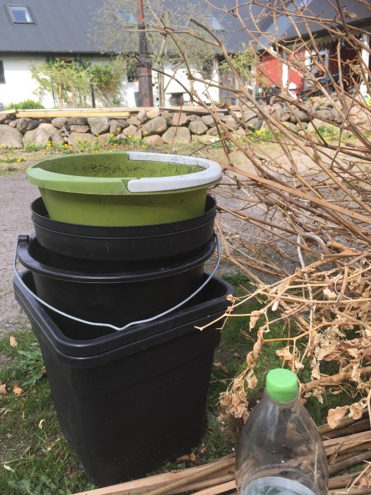 Hinkar och krukor staplade utomhus, redo att rengöras inför ny säsong av växtodling.