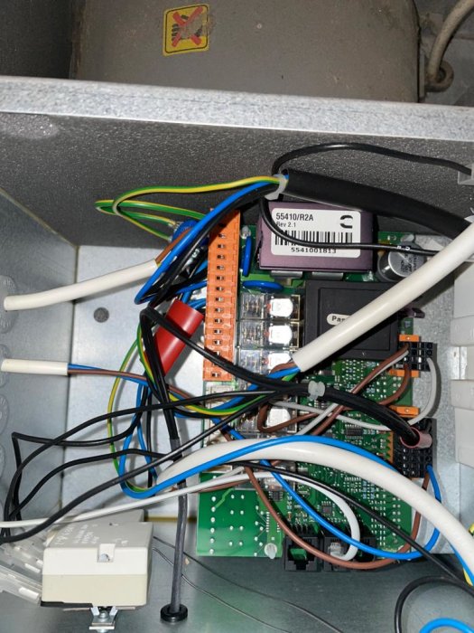 Kretskort och kablage inuti en ventilationsanläggning, med synliga komponenter och anslutningar.
