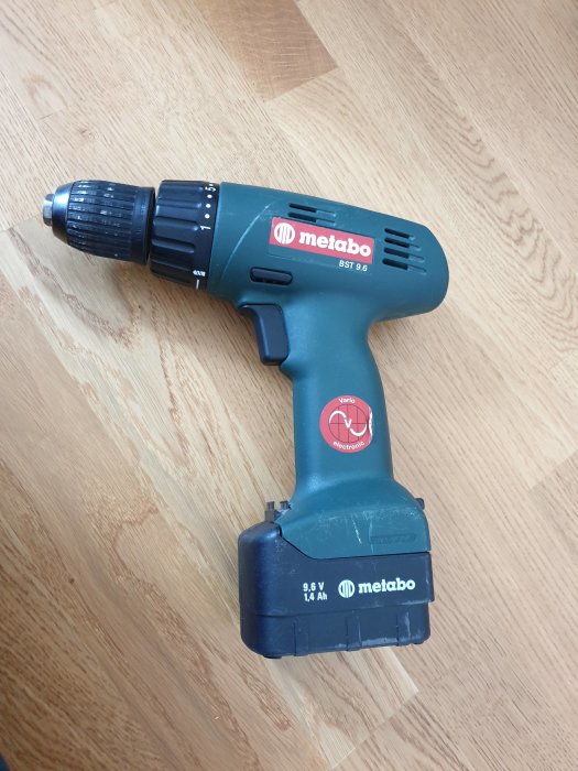 Gammal Metabo skruvdragare modell BST 9.6 på trägolv, med synligt batteri och märkning.