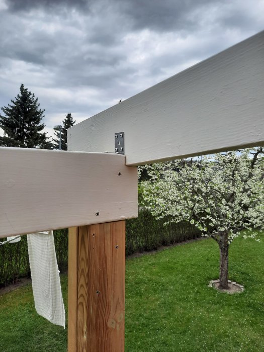 Minimal urjackning i träbjälke för att montera stödben under takbjälke med vinkeljärn, i en trädgård.