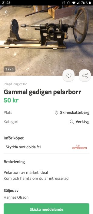 Gammal manuell pelarborr med stort vevhjul och växlar, placerad på ett verkstadsgolv.