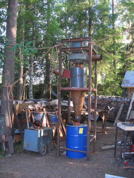Hembyggd cyklon dammavsugningsanordning med en stor fläkt och metallkomponenter monterade utomhus.