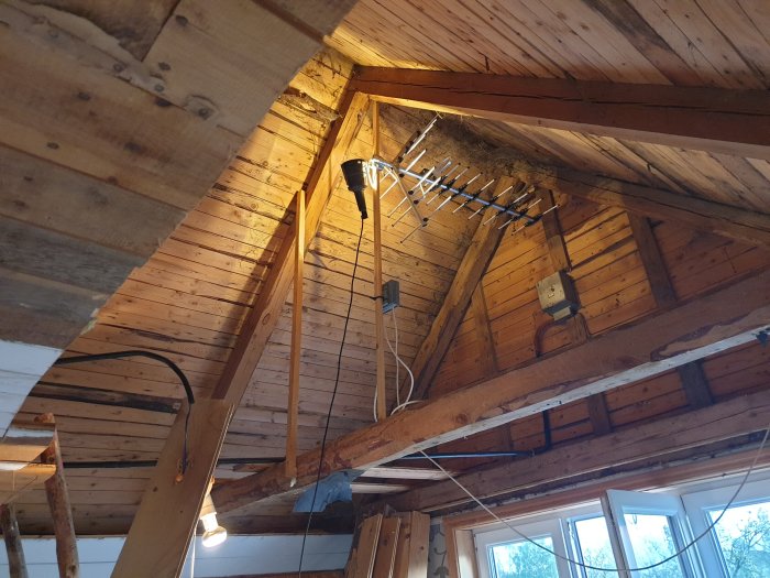 Renoveringsprojekt inledning med exponerade träbjälkar och takkonstruktioner i ett hus under renovering.