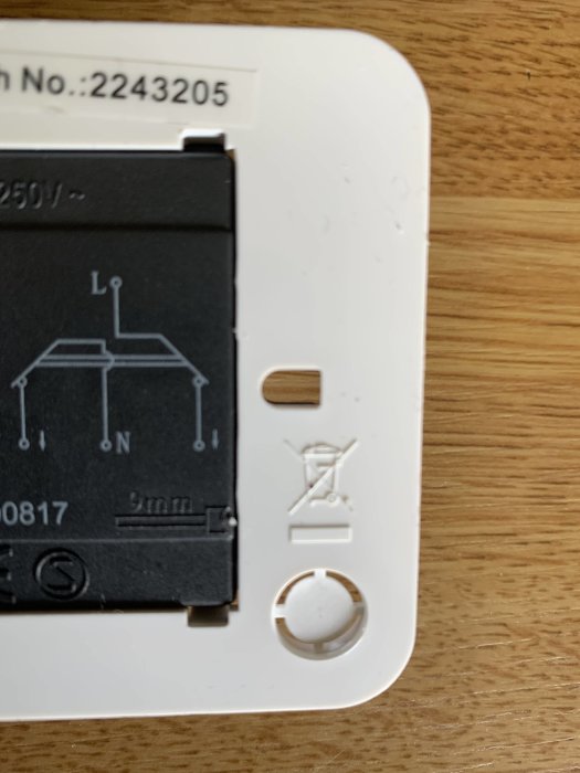 Eluttag bakifrån med öppen kabelanslutning och diagram, monterat på träunderlag.