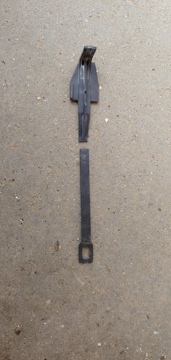 Trasig plastdel, antagligen en startknapp, till en lackfräs på ett stenigt underlag.