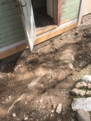 Bild av villaentré med bergshäll som lutar in mot huset där en farstukvist ska byggas.