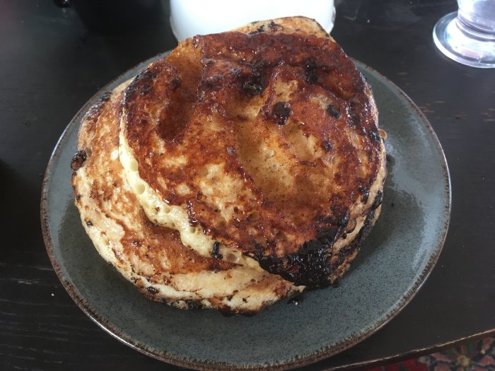 Hembakade kanelbulle-pannkakor på en tallrik, något brända men ändå aptitliga.