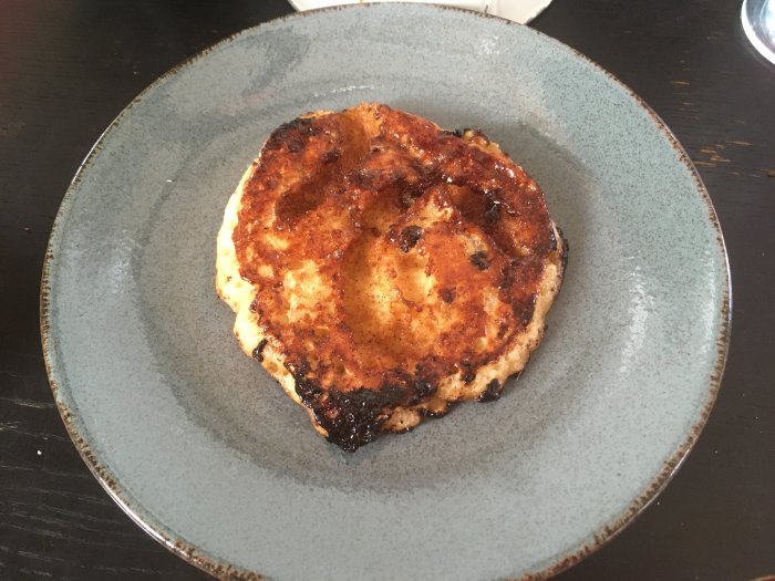Panncake med kanelbulle-design något bränd på en keramiktallrik.