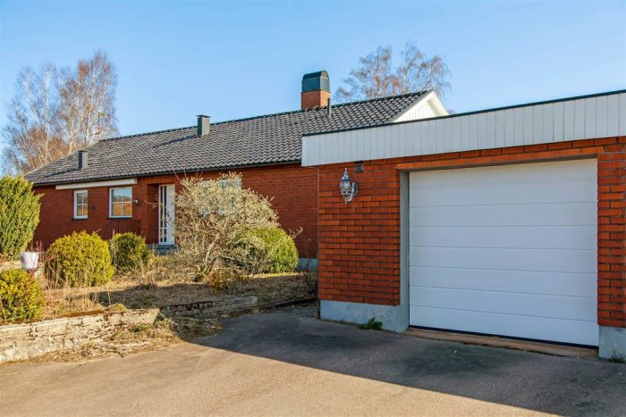 Enplans tegelhus från 1968 med garage och övervuxen trädgård, beläget i Snöstorp.