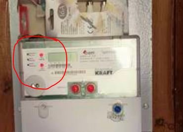 Elektrisk säkringsskåp med två röda indikatorljus på, inringat för att indikera eventuell frågeställning.