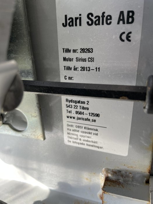 Etikett på jalusiportens motor med texten "Jari Safe AB, Motor Sirius CSI, Tillv.nr 2013-11".